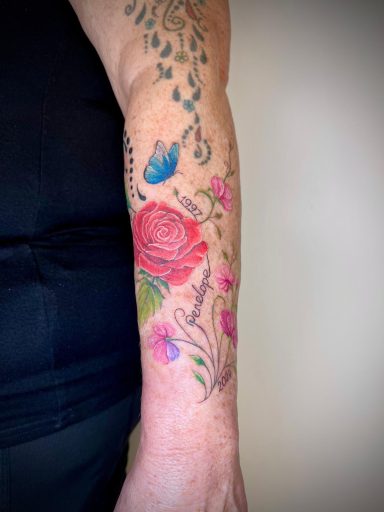 Colour rose and butterfly forearm tattoo with personalised name and dates by Lena Luna Tattoo