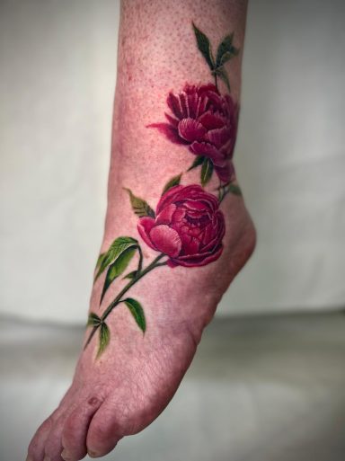 Realistic red peony foot tattoo with botanical details by Lena Luna in Letchworth Hertfordshire
