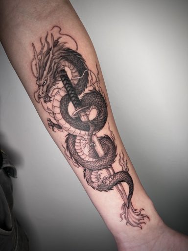 Black and grey Chinese dragon forearm tattoo by Lena Luna Tattoo in Hertfordshire