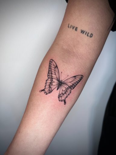 Fine line butterfly tattoo on the forearm