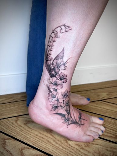 Lilly of the valley ankle and foot tattoo in black and grey by Lena Luna Tattoo in Letchworth, Hertfordshire